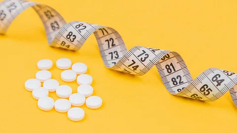 Image showing a measuring tape with some tablets beside it.