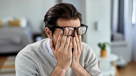 A man has placed his hands on his face in exhaustion.