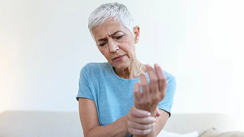 Image depicting old lady suffering from Rheumatoid Arthritis.