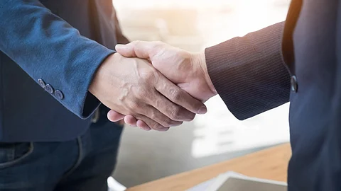 A handshake between a patient advocate and a researcher, representing collaboration in transforming clinical trials.