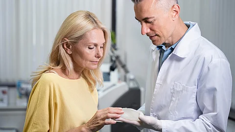 Image shows doctor consulting a patient about skin cancer concerns.