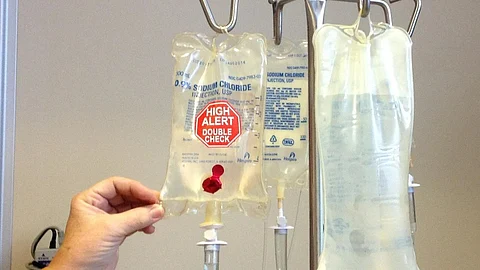 Image shows photograph of an IB bag with a red " High Alert" and another bag contains a clear liquid, indicating administration to a patient.