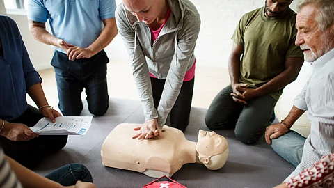 A group of people practicing CPR on a dummy.