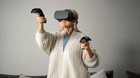 Image shows woman using a virtual reality headset and controllers.