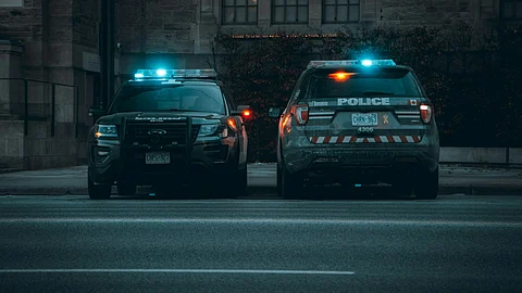 two police cars parked on the side of the road