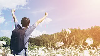 Image shows person radiating cheerfulness on a mountain.