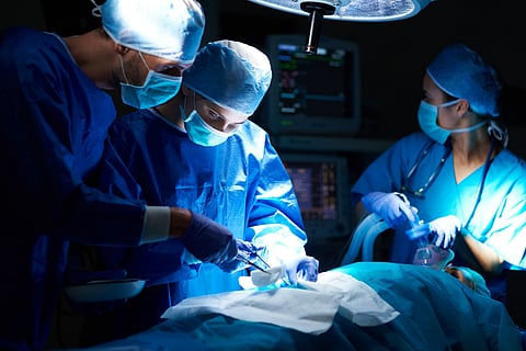 Surgeons performing operation in operation room