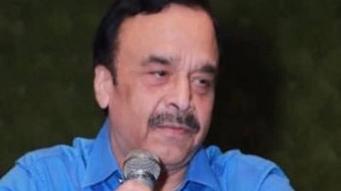 Image of Dr. Surinder Singla in a blue shirt and holding a mic in one of his hand.