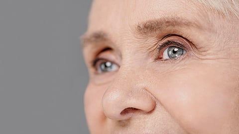 Close-up shot of an older woman’s greyish-colored eyes.
