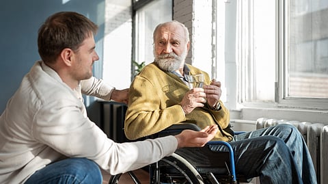 Image of an old person prolly suffering from dementia with a care-taker.