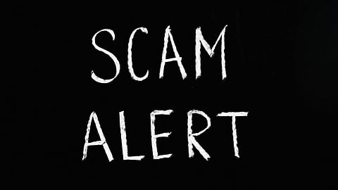 An image with black background and white text saying Scam alert.