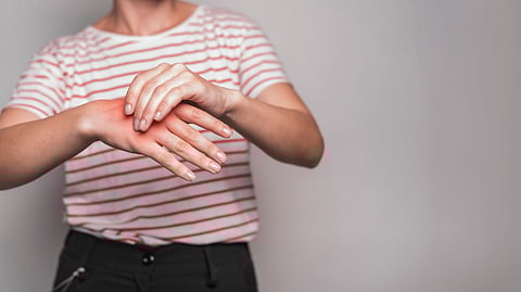 Image of a woman holding her hand with another one because of pain.