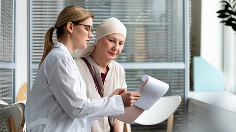 Image of a doctor consulting a patient suffering from cancer in a clinical setting.