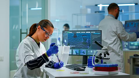 Image of scientists working in modern scientific laboratory with proper majors and precautions.