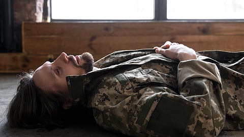 An image of a soldier lying down and trying to sleep using Military Sleep Method.