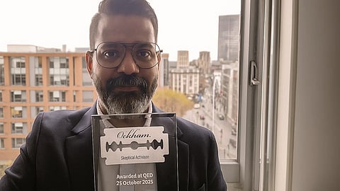 An image of Dr. Cyriac Abby Philips holding the memento of the award.