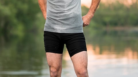 Image of a man wearing a grey t-shirt and a black shorts.