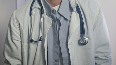 An image of a person in a white doctor's coat and stethoscope around his neck.