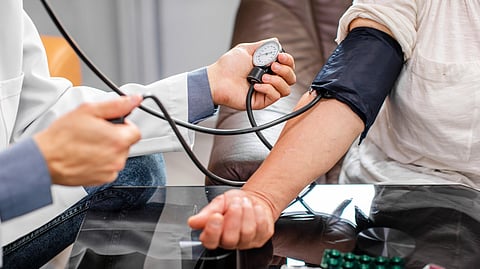 Image of a doctor measuring blood pressure of a patient.