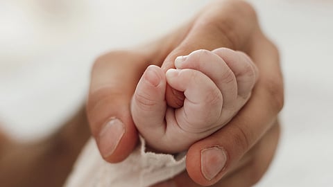 Image of a hand of newborn holding his mother's hand.