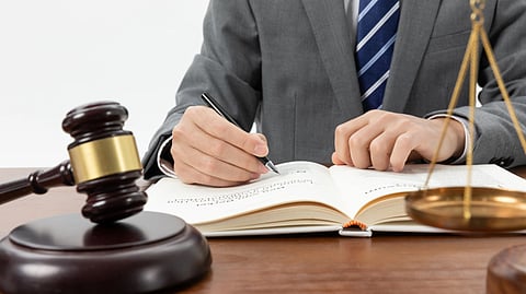 Image of a lawyer writing something on the paper.