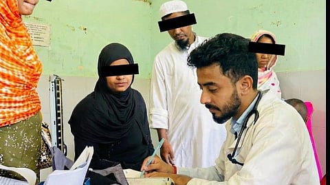 An image of Dr. Priyam sitting with patients.