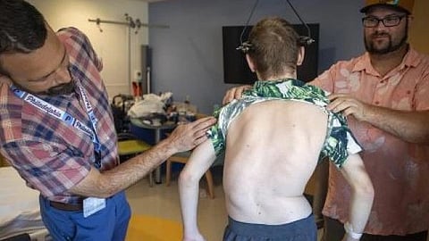 An image of a men help another man with back support.