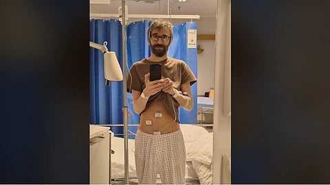 Mirror selfie of a man in a hospital room with an IV drip attached after a laparoscopic appendectomy.