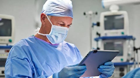 An image of a doctor in surgery holding an ipad.