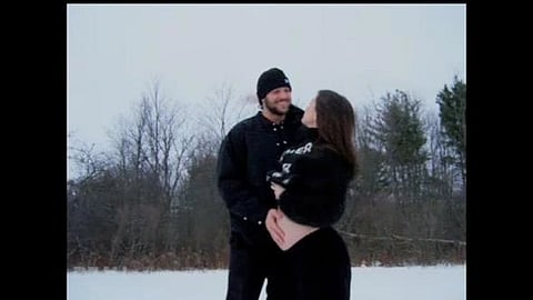 A picture of Josh Allen and wife Hailee Steinfeld pictured on a snowy outdoor background with matching black outfits with the baby bump.
