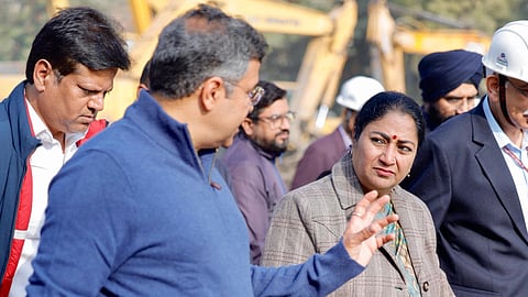 An image of Delhi Chief Minister Rekha Gupta walking with Health Minister Pankaj Kumar and a group of people.