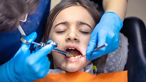 A child patient in a dentist's office undergoing treatment.