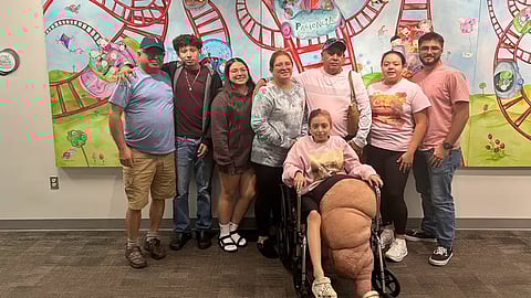 A family photo of Ramirez family, where Jasmine is sitting in a wheelchair.