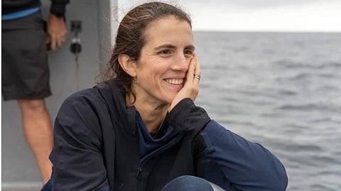 A portrait of Tatiana Schlossberg sitting on a boat in the sea.