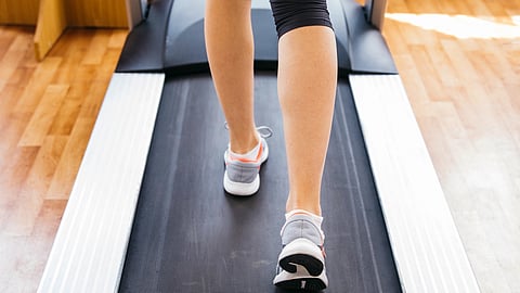 An image of a woman walking on a walking pad.