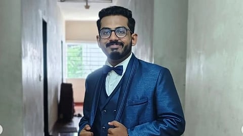 An image of Dr. Aswin Paul in a blue suit in a corridor.