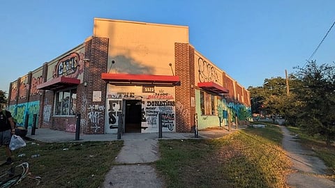 A brick building covered in colorful graffiti, including various tags and art.