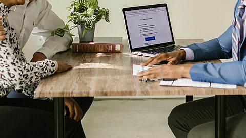 A consultant meeting with a couple in a professional office setting.