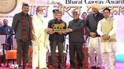 Laxmikant Tiwari receiving the Bharat Gaurav Award on the stage.