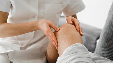 A healthcare professional gently massages a person's knee.