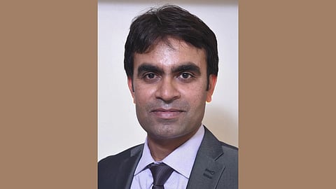 Portrait of Dr. Chandrakant Lahariya smiling, wearing a grey suit.