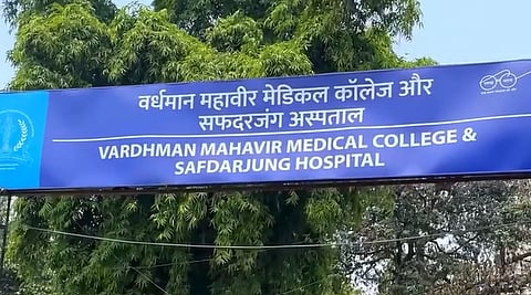 A big name board of Safdarjung hospital and the hospital building.