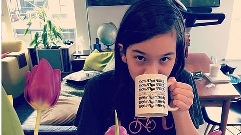 An image of Penelope Sokolowski, holding a mug with something written on it. She is wearing a black top.