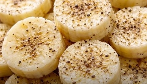Banana slice sprinkled with black pepper.