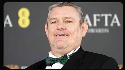 Image of John Davidson wearing a black blazer with a bow tie.