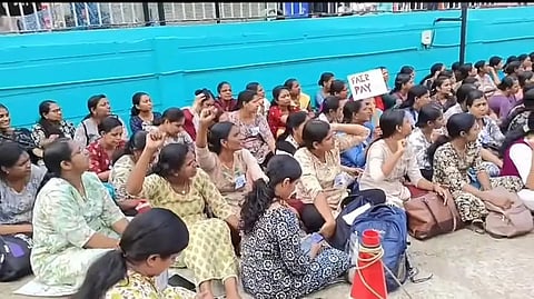 Several women sitting on road and protesting.