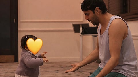 A picture where Varun Dhawan with his daughter who is trying her first steps and learning to walk.