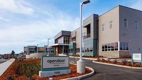Modern health center with large windows, clear signage, and landscaped surroundings.