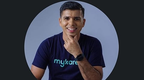 Senu Sam in a navy blue tshirt with mykare written.