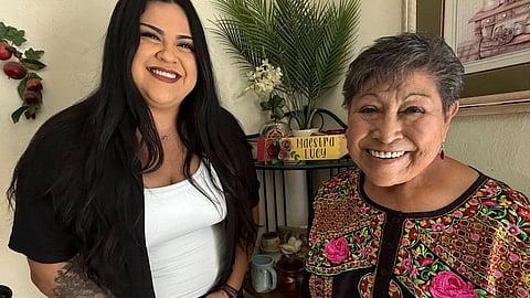 Two women smile together.